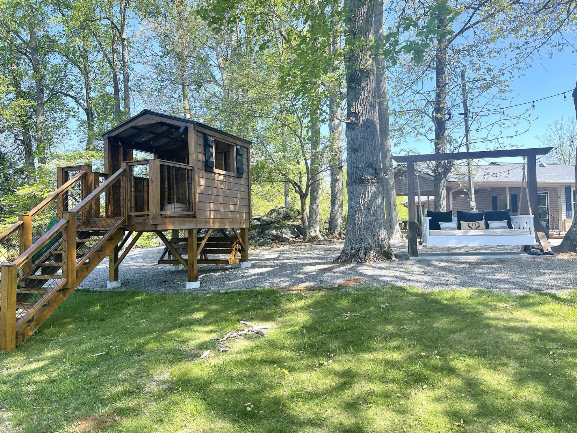 Outdoor bed swing under pergola with string lights at Tranquille Resort on Lake Chatuge