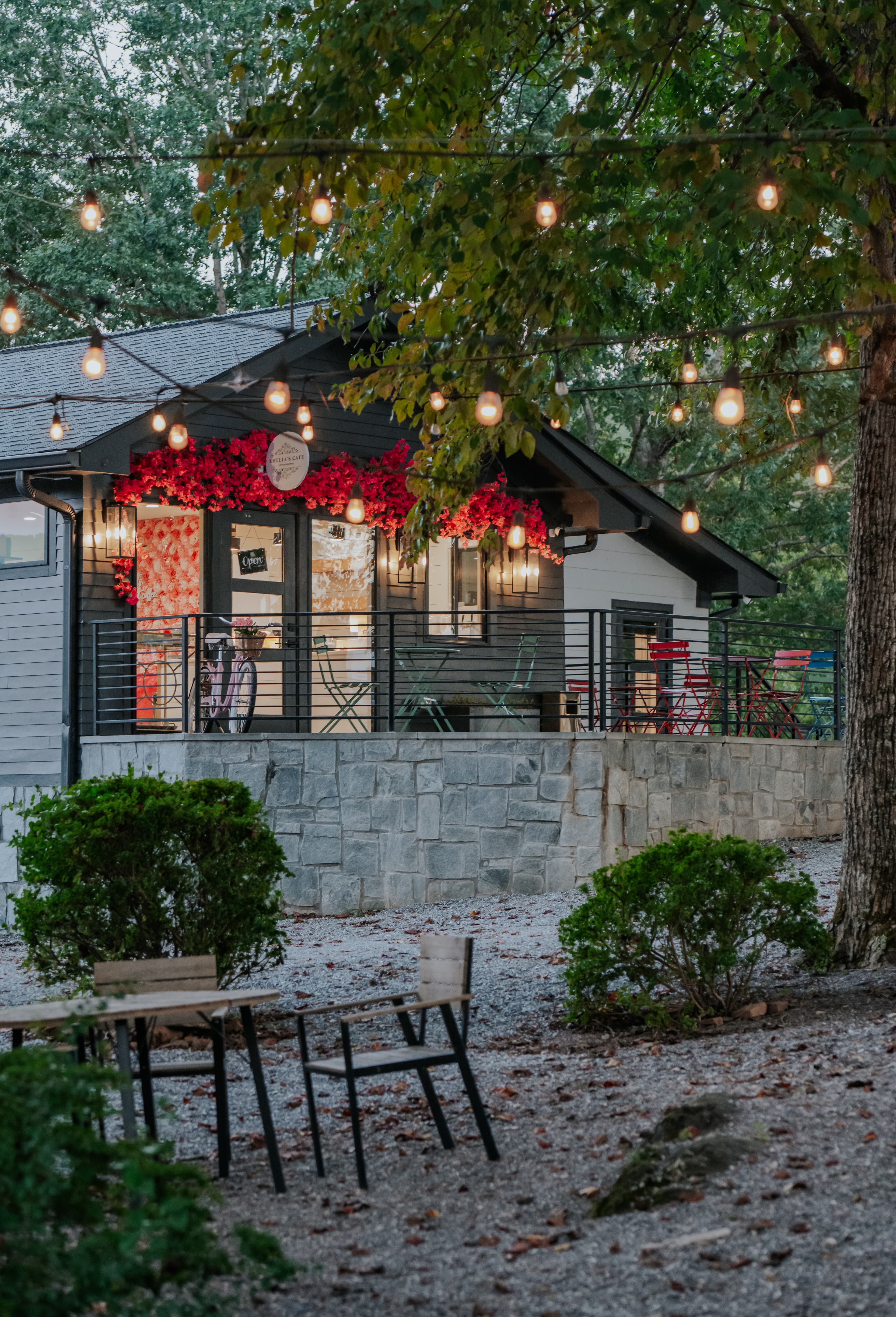 Amelia's Cafe at Tranquille Resort with string lights and red flowers at dusk — on-site cafe for family reunion guests